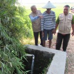 PPL Kecamatan Adipala, Pono (kiri) bersama petani mengamati volume air yang dihasilkan satu pompa (Foto:sembada/henry)