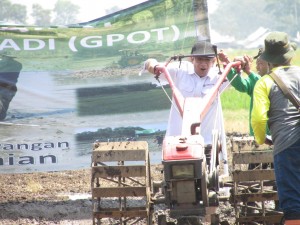 Ugi Sugiharto mencoba traktor tangan (roda dua) pada percepatan pengolahan tanah untuk tanam padi di musim kemarau (Foto:sembada/rori)