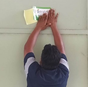 Pengelola SP3T Ngudi Makmur Fakih Hanafi menempelkan tulisan KONSTRALING di dinding depan SP3T Desa Purworejo untuk menandakan SP3T itu adalah bantuan Kementerian Pertanian (Foto:sembada/rori)
