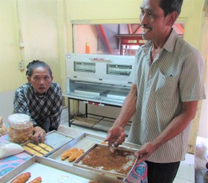 Susi Gusliani (kiri) menyaksikan suaminya, Rasito menunjukkan panir sorgum olahannya untuk merenyahkan ayam kentucky dan kue kering ebi  (Foto:sembada/rori)