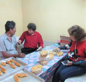 Rasito (kanan) pembuat roti dan kue berbahan sorgum meminta Dewi Kaniati (44, kanan) bercerita alasan sering membeli kue ke rumahnya (Foto:sembada/rori)